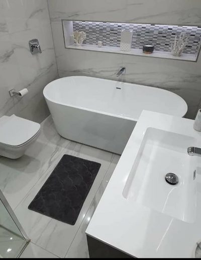 Birds eye view of bathroom. Free standing white bath, with floating toilet and wash hand basin.
